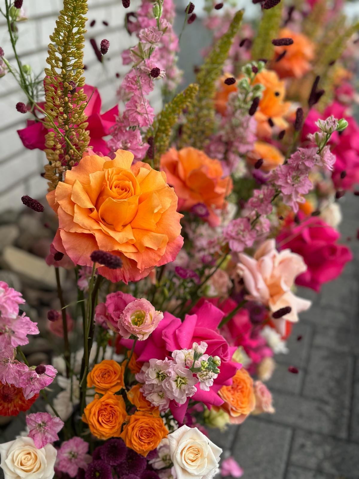 Farbige Hochzeitsblumen und Flower Wall als florales Statement