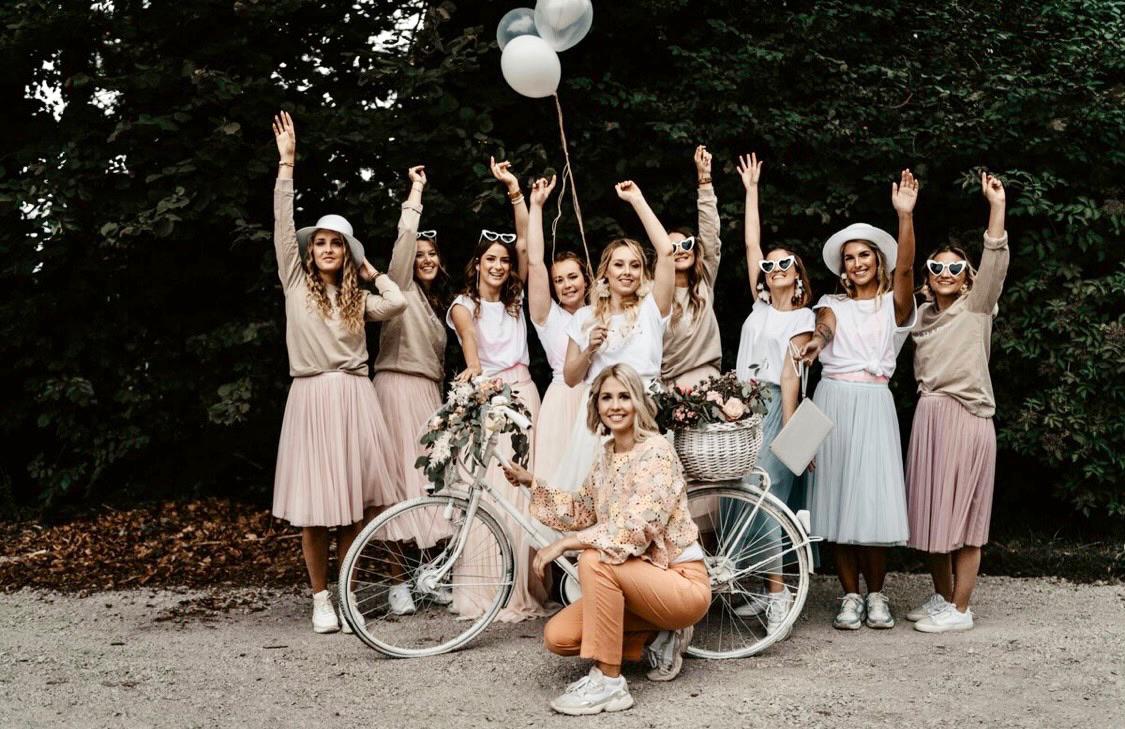JGA-Gruppe mit Braut, Blumen und Ballons